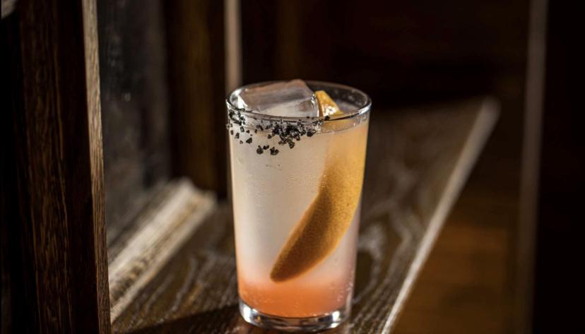 A citrus-forward coastal cocktail with a dark salt rim
