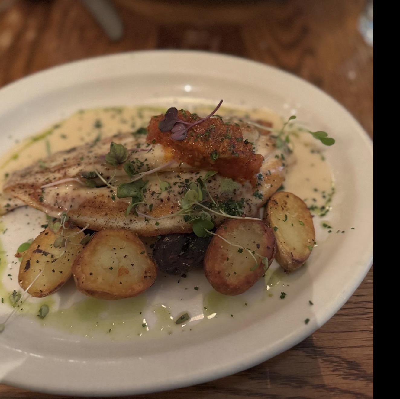 Pan-seared Atlantic fish with roasted potatoes and seasonal garnish