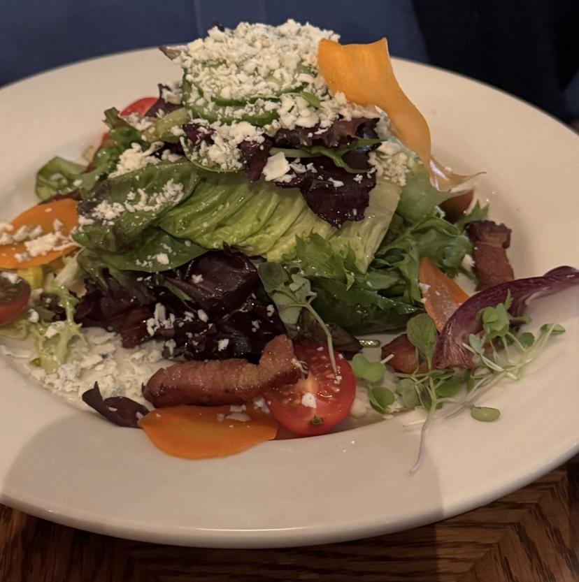 A seasonal green salad with fresh vegetables and crumbled cheese