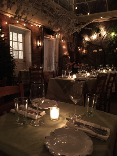 An intimate candlelit dining room prepared for attentive evening service